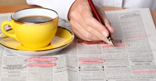 Man looking for a job in newspaper