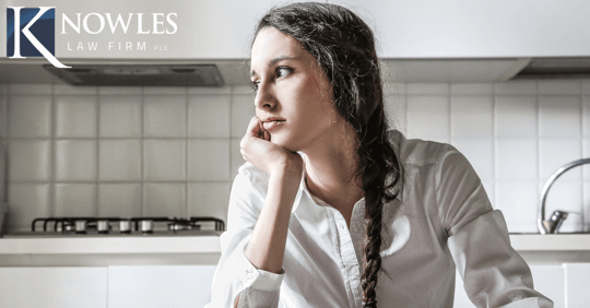 woman looking sad, head resting on hand