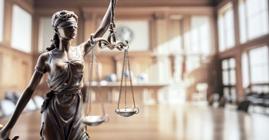 Scales of justice in courtroom background