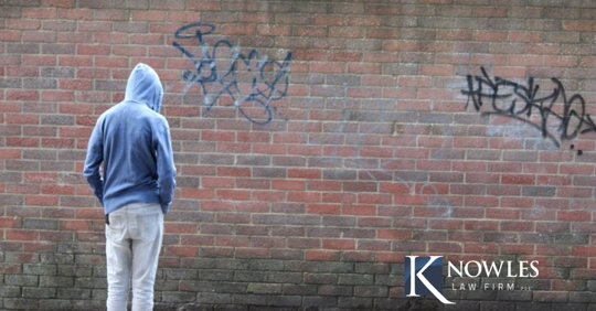 kid starting at graffiti wall